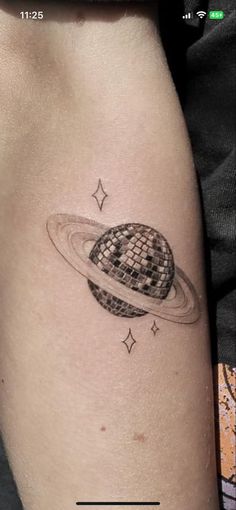 a small saturn tattoo on the right side of the leg, with stars around it