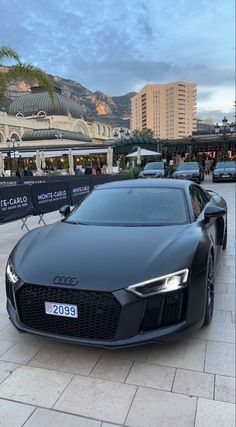 a black sports car parked in front of a building on the side of a road