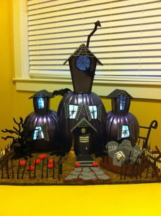 a table topped with lots of fake pumpkins next to a window covered in halloween decorations