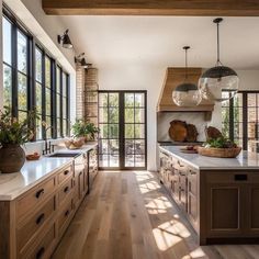 a large kitchen with wooden cabinets and white counter tops, along with lots of windows