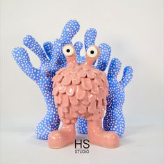 a blue and pink figurine with polka dots on it's arms, eyes and legs