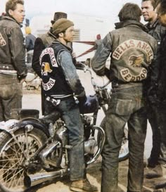 a group of men standing around a motorcycle