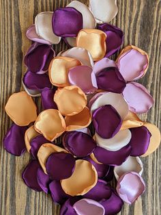 purple and orange pieces of fabric sitting on top of a wooden table