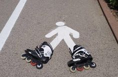 two skateboarders are standing in the middle of an empty parking lot with their feet on rollers