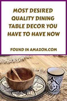 a wooden bowl sitting on top of a table next to two cups and saucers