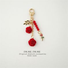 a key chain with roses and a cross hanging from it's end, on a white background