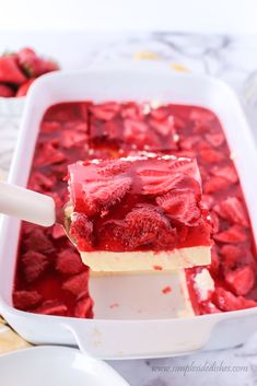 strawberry cheesecake bars in a white dish with a spoon sticking out of the top