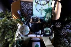 a table topped with lots of assorted items on top of a green cloth covered floor