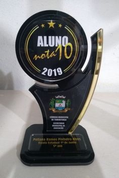 an award is displayed on a white surface with a black and gold trophy in the foreground