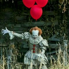 a creepy clown with red balloons in the air