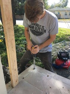 a young man is working on a piece of wood with a drill and screwdriver