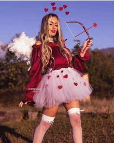 a woman in a red dress holding a bow and arrow with hearts on her tutu