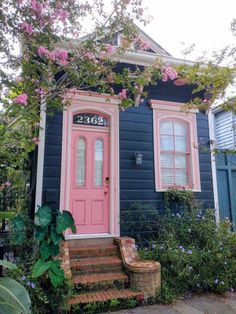 a blue house with pink door and steps