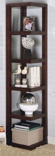 a corner shelf with books and pictures on it