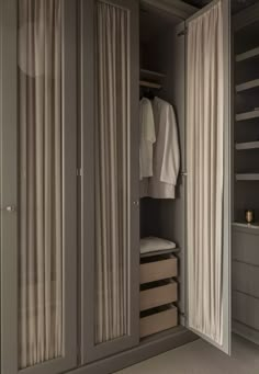 an open closet with clothes hanging in it