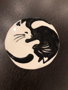 a black and white plate with a cat painted on it