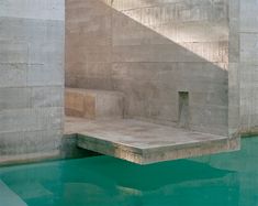 an empty swimming pool with steps leading up to the water's edge and sun shining on it