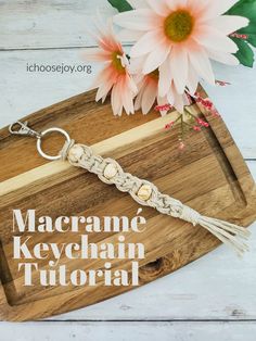 the macrame keychain is sitting on top of a wooden cutting board