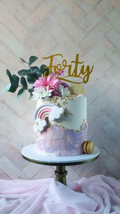 a pink and gold cake with flowers on top