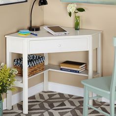 a white desk with a laptop computer on top of it next to a blue chair