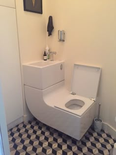 a white toilet sitting in a bathroom next to a black and white checkered floor