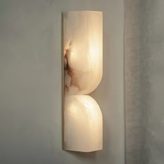 a white wall light mounted on the side of a wall