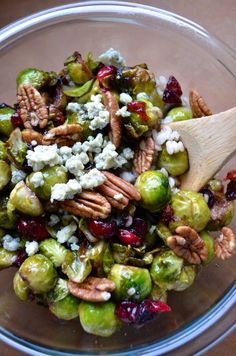 brussel sprouts with walnuts, cranberries and feta cheese in a glass bowl