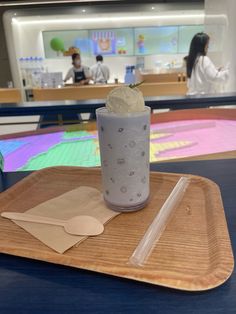 an ice cream sundae sits on a wooden tray