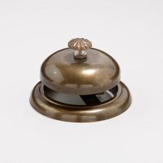 an antique brass bell on a white background with a black stripe around the bottom half