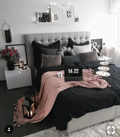 a black and white bedroom with candles on the nightstands, bedding and decor