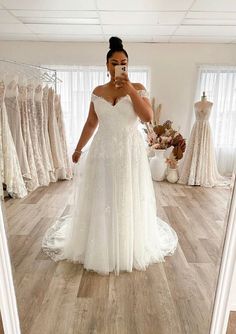 a woman taking a selfie in front of a mirror while wearing a wedding dress