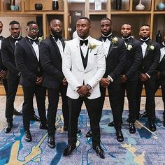 a group of men standing next to each other in tuxedos and bow ties