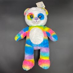 a multicolored teddy bear with a tag on it's ear and eyes