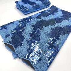 blue sequins and beads are on top of a table cloth with matching place mats