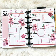 an open planner with pink flowers on it