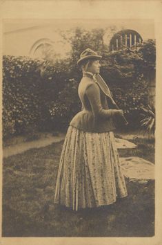 an old black and white photo of a woman in a dress