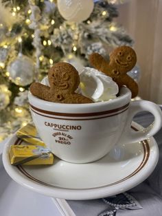 a cup filled with marshmallows and cookies on top of a saucer