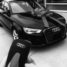 a black and white photo of an audi car with a bow on it's hood