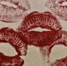 red lipstick drawn on white paper with different shapes and sizes in the middle, surrounded by smaller lips