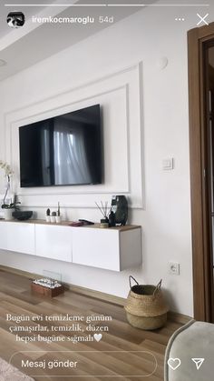 a flat screen tv mounted to the side of a white wall in a living room