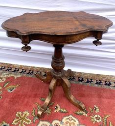 an old wooden table sitting on top of a rug