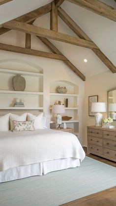 a bedroom with white bedding and wooden beams