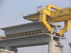 there is a large yellow crane on top of a tall structure in the middle of nowhere