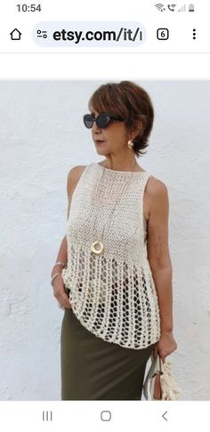 an older woman wearing sunglasses and a crochet top is standing in front of a white wall