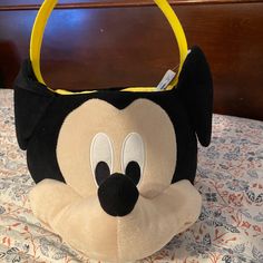 a mickey mouse purse sitting on top of a bed