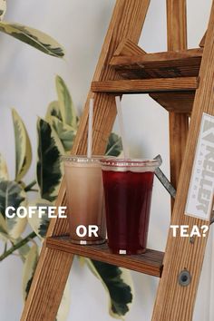 two drinks sitting on top of a wooden ladder next to a sign that says coffee or tea?