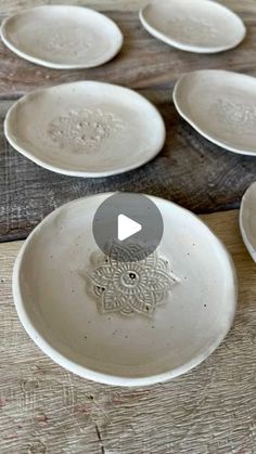 several white plates sitting on top of a wooden table