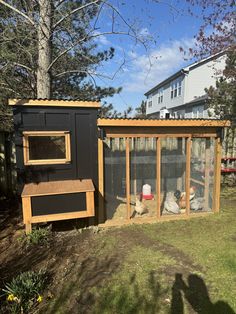 the chicken coop is built into the side of the house and has two chickens in it