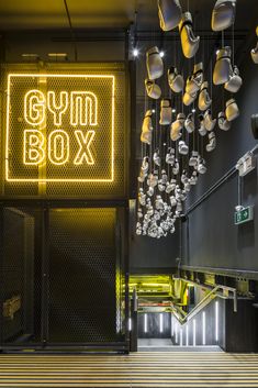 the gym box is lit up with yellow lights and chandeliers hanging from the ceiling