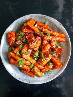 a white bowl filled with sesame seed tofu